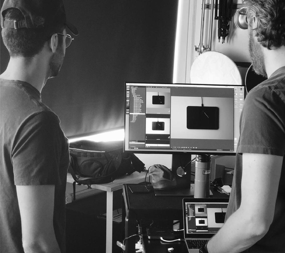 Two men looking at computer with Courant designs