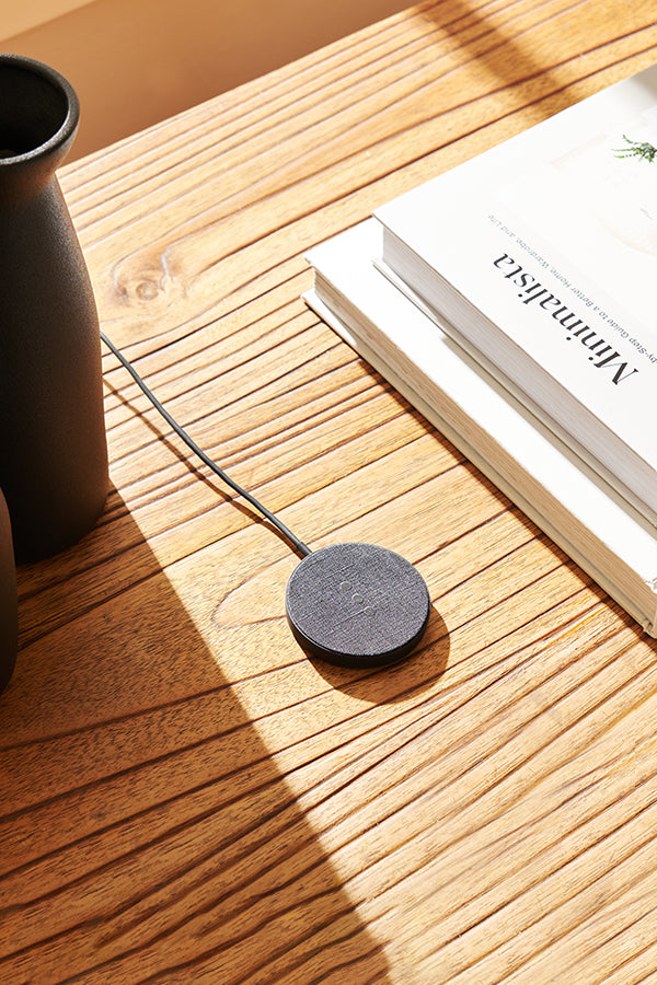 Black charger on wood desk
